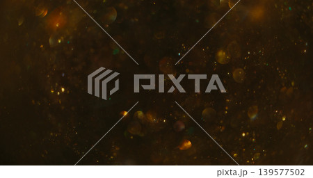 Confetti texture blur. Color bokeh blink. Golden shimmering snow stream on dark abstract background. Night circles reflection mix. Confetti texture blur. Color bokeh blink. Golden shimmering snow stream on dark abstract background. Night circles reflection mix. 139577502