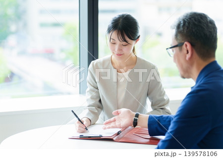 契約書にサインをする女性 契約書にサインをする女性 139578106
