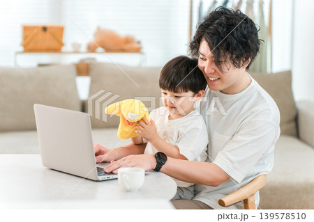 リビングでパソコンを見ながら過ごす親子 リビングでパソコンを見ながら過ごす親子 139578510