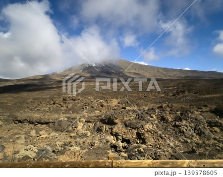 Volcanic mountain landscape under cloudy blue sky 139578605
