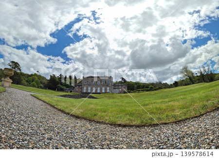 Historic country mansion with landscaped gardens and dramatic sky 139578614