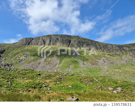 Green mountain cliff under blue sky 139578631