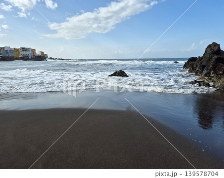 Waves washing onto a black sand beach Waves washing onto a black sand beach 139578704