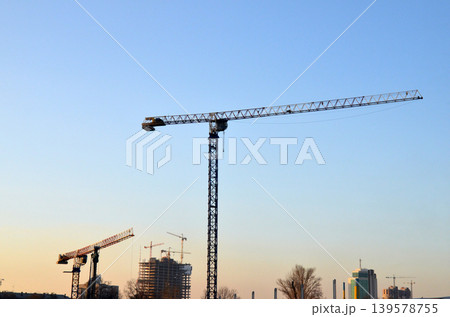 Tower cranes above construction site at sunset Tower cranes above construction site at sunset 139578755