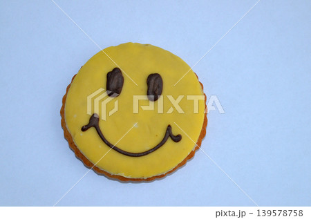 Smiling face cookie on blue background Smiling face cookie on blue background 139578758