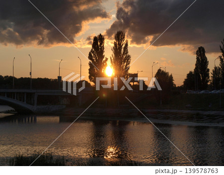 Sunset Over River With Bridge and Silhouetted Trees Sunset Over River With Bridge and Silhouetted Trees 139578763
