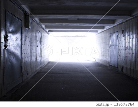 Dark underground tunnel with bright exit light 139578764