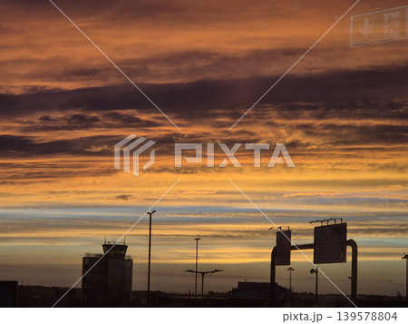 Golden sunset sky over airport silhouettes Golden sunset sky over airport silhouettes 139578804