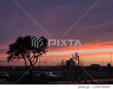 Sunset sky over silhouetted tree and parking area 139578805