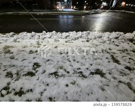 Snow Covered Grass Beside Wet Road at Night 139578829