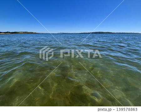 Clear blue sea with distant coastline and horizon Clear blue sea with distant coastline and horizon 139578863