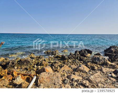 Rocky shoreline with calm blue sea and clear sky Rocky shoreline with calm blue sea and clear sky 139578925