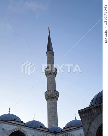 Tall mosque minaret against clear blue sky Tall mosque minaret against clear blue sky 139579045