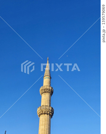 Tall minaret against clear blue sky 139579069