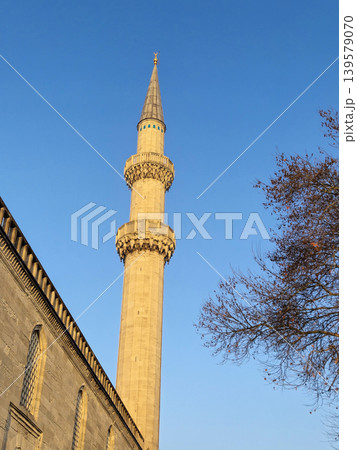 Tall mosque minaret against clear blue sky Tall mosque minaret against clear blue sky 139579070