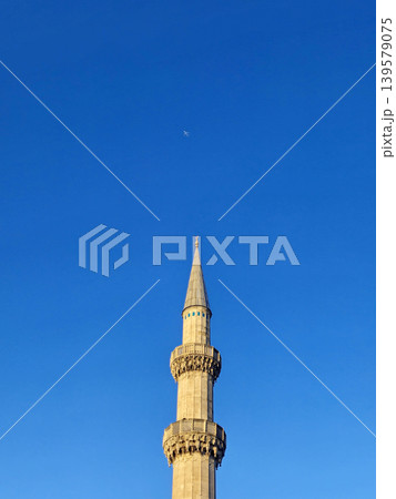 Tall mosque minaret against clear blue sky 139579075