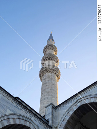 Tall mosque minaret against clear blue sky Tall mosque minaret against clear blue sky 139579085