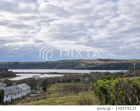 Cloudy rural landscape with lake and rolling hills 139579115