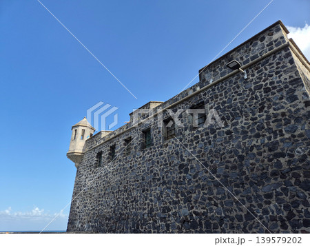 Historic stone fortress wall under clear blue sky Historic stone fortress wall under clear blue sky 139579202
