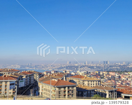Cityscape with rooftops and distant skyline under blue sky 139579328