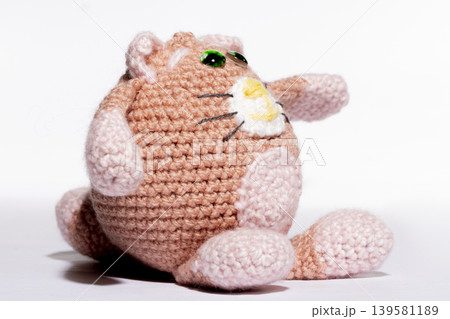 Knitted white cat on a white background Knitted white cat on a white background 139581189