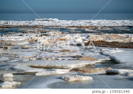 Floating ice pieces break apart on water in a coastal area during morning light. Floating ice pieces break apart on water in a coastal area during morning light. 139581340