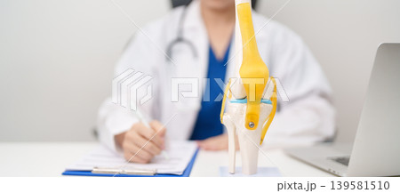Doctor with Human Knee joint anatomy model. Osteoarthritis, Patellofemoral Pain Syndrome, Patellar Tendinitis, ACL, Anterior Cruciate Ligament, PCL, Posterior, MCL, Medial Collateral, LCL and Lateral 139581510
