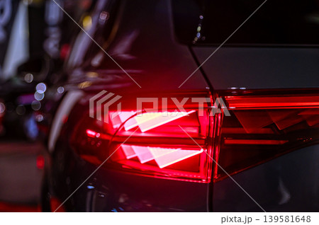Car taillight shines bright on a city street during nighttime driving Car taillight shines bright on a city street during nighttime driving 139581648