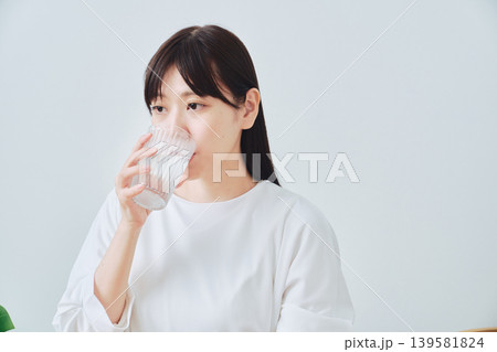 コップの水を飲む若い女性 139581824