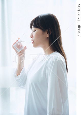 朝の窓辺で水を飲む女性 朝の窓辺で水を飲む女性 139581835