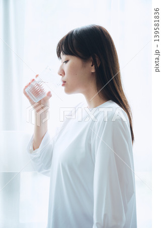 朝の窓辺で水を飲む女性 朝の窓辺で水を飲む女性 139581836