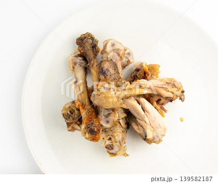 Chicken Leftovers, Unfinished Grilled Chicken on Dirty Plate Isolated, Meat Pieces and Bones after Dinner Chicken Leftovers, Unfinished Grilled Chicken on Dirty Plate Isolated, Meat Pieces and Bones after Dinner 139582187