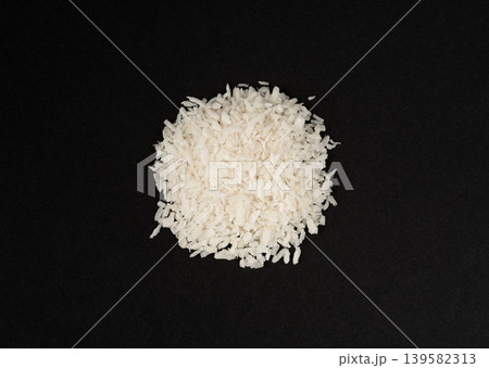 Grated coconut powder. Dry coco flakes pile, shredded desiccated coconut, tropical fruit chips Grated coconut powder. Dry coco flakes pile, shredded desiccated coconut, tropical fruit chips 139582313