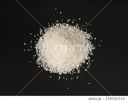 Grated coconut powder. Dry coco flakes pile, shredded desiccated coconut, tropical fruit chips 139582314