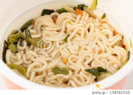 Dry instant noodles in cup isolated. Raw spaghetti in a plastic cup, fast food pasta in container Dry instant noodles in cup isolated. Raw spaghetti in a plastic cup, fast food pasta in container 139582550