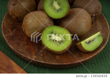 Kiwi fruits slices on wood cutting board Kiwi fruits slices on wood cutting board 139582638