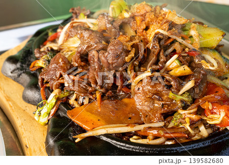 Sizzling beef fajita platter, asian beef stir fry in skillet closeup Sizzling beef fajita platter, asian beef stir fry in skillet closeup 139582680