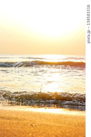 Tranquil seascape on sunset background. Soft sandy shore with warm. Waves at shoreline Tranquil seascape on sunset background. Soft sandy shore with warm. Waves at shoreline 139583316