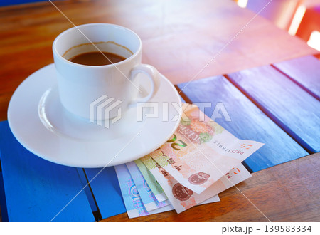 Coffee cup on table with yuan bill money cafe. Payment coffee drink on breakfast. Yuan biill money  139583334