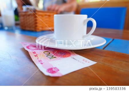 Coffee cup on table with yuan bill money cafe. Payment coffee drink on breakfast. Yuan biill money  139583336