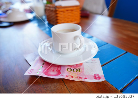 Coffee cup on table with yuan bill money cafe. Payment coffee drink on breakfast. Yuan biill money  139583337