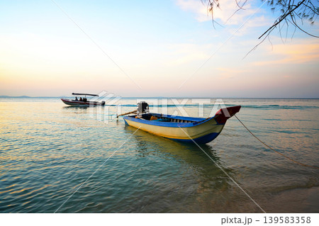 Fishing boats at shore on sunset. Fishermen's boats in sea at  shore in fishing village  139583358
