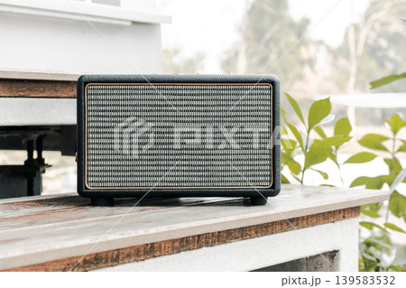 Vintage Bluetooth Speaker on Wooden Stairs in Garden with Morning Sunlight Lifestyle Concept Vintage Bluetooth Speaker on Wooden Stairs in Garden with Morning Sunlight Lifestyle Concept 139583532