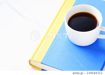 読書 - 香りのよい淹れたてのコーヒーを飲みながら、のんびり読書を楽しんでいるイメージ 読書 - 香りのよい淹れたてのコーヒーを飲みながら、のんびり読書を楽しんでいるイメージ 139584312