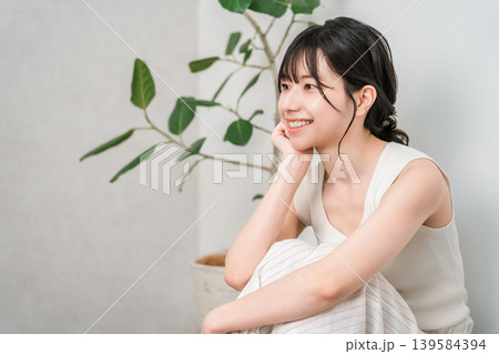 フローリングに座る笑顔の美しいアジア人女性の横顔(美容・ダイエット・脱毛) フローリングに座る笑顔の美しいアジア人女性の横顔(美容・ダイエット・脱毛) 139584394