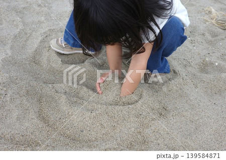 海岸の砂浜で砂山を両手で作って遊ぶ子供の手元 海岸の砂浜で砂山を両手で作って遊ぶ子供の手元 139584871