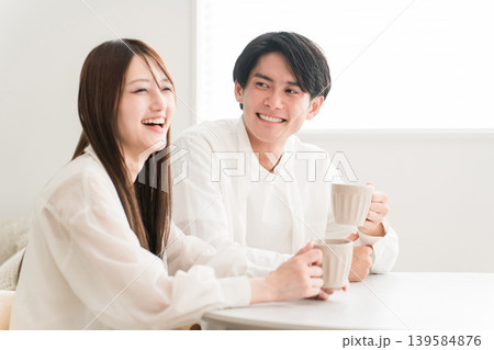 ダイニングテーブルでホットドリンクを飲みながら会話するカップル,夫婦 ダイニングテーブルでホットドリンクを飲みながら会話するカップル,夫婦 139584876