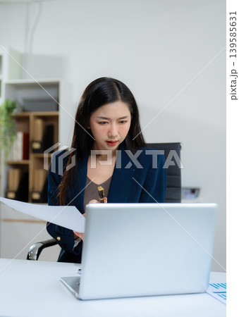 Businesswoman analyzing financial graphs, calculating company expenses. 139585631