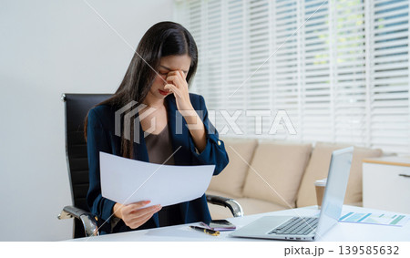 Stress businesswoman is sitting at table, under stress from working. 139585632