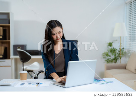 Businesswoman analyzing financial graphs, calculating company expenses. Businesswoman analyzing financial graphs, calculating company expenses. 139585652
